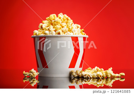 A box of fluffy popcorn against a vibrant red background A box of fluffy popcorn against a vibrant red background 121641085