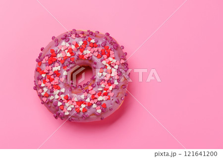 A sweet donut adorned with heart-shaped decor on a pink background A sweet donut adorned with heart-shaped decor on a pink background 121641200