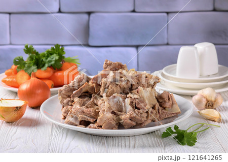 pork and beef bones with leftover meat after cooking broth on a white plate pork and beef bones with leftover meat after cooking broth on a white plate 121641265