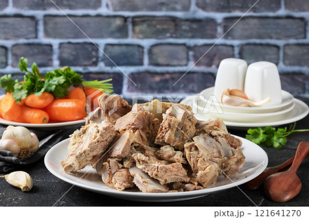 pork and beef bones with leftover meat after cooking broth on a white plate pork and beef bones with leftover meat after cooking broth on a white plate 121641270