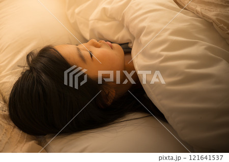 間接照明のある部屋でベッドで眠る子供 間接照明のある部屋でベッドで眠る子供 121641537