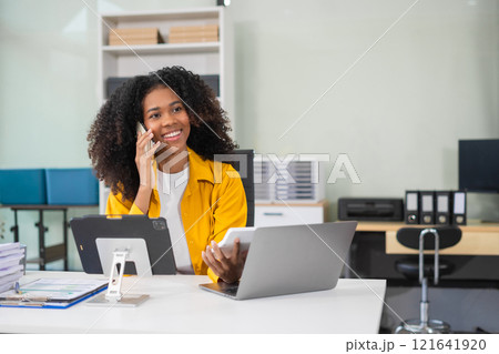 Business woman talk mobile phones and working on laptop computers, online business. 121641920