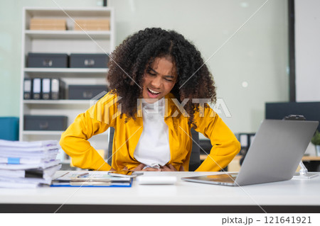 Businesswoman is doing a stretchy posture due to sitting in the office for too long, office syndrome concept. 121641921