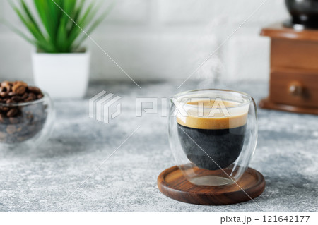 espresso in glass cup on table on white brick wall background espresso in glass cup on table on white brick wall background 121642177