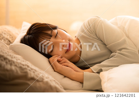 間接照明で眠りにつく女性 ベッドの睡眠や安眠のイメージ 間接照明で眠りにつく女性 ベッドの睡眠や安眠のイメージ 121642201