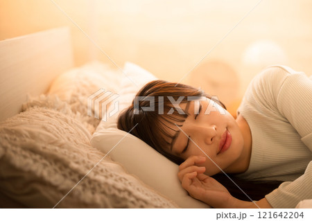 間接照明で眠りにつく女性　ベッドの睡眠や安眠のイメージ 121642204