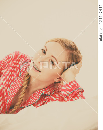 Smiling woman lying in bed Smiling woman lying in bed 121642452
