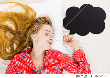 Young woman lying on bed wearing pajamas 121642455