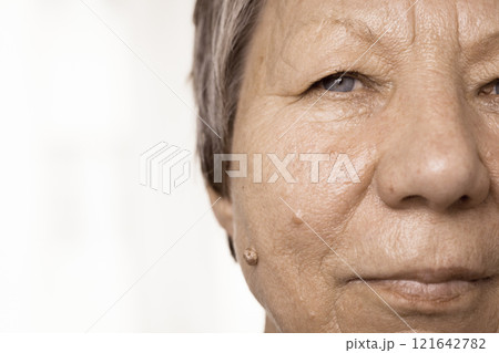 Elderly pensioner female half face portrait closeup 121642782