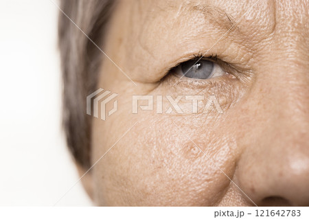 Elderly pensioner female half face portrait closeup 121642783