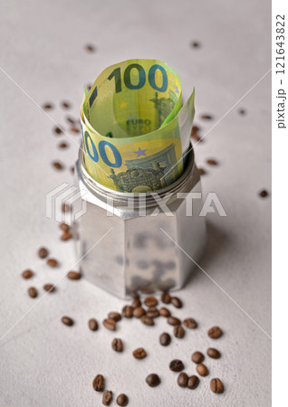 100 Euro paper cash banknotes in a geyser coffee maker moka machine. The rise in the price of coffee around the world 121643822