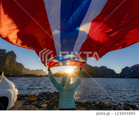 Woman with a waving flag of Norway on the background of nature 121643885