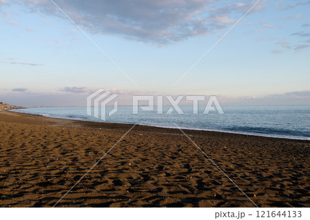 西日が差し込む冬の夕方の穏やかなビーチ 121644133