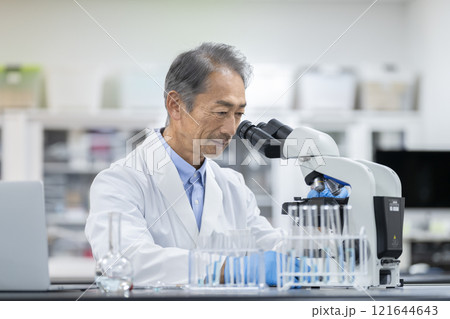 顕微鏡で作業をする白衣を着たシニア男性　実験・研究・開発イメージ 121644643