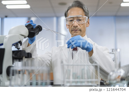 研究・実験イメージ 試験管とスポイトで作業をする白衣を着たシニア男性 研究・実験イメージ 試験管とスポイトで作業をする白衣を着たシニア男性 121644704