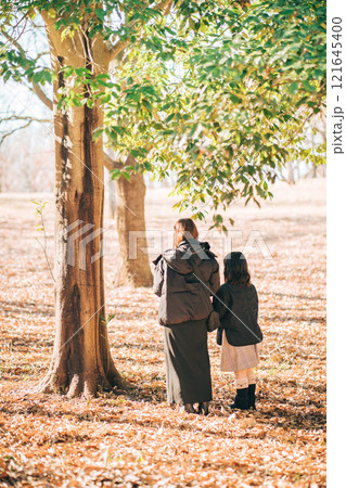 公園の木の下に立つお母さんと子供 121645400