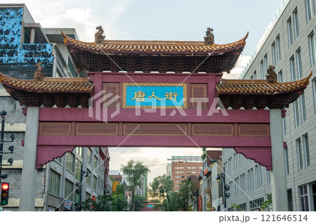 Montreal, Quebec, Canada - August 11 2021 : Street view of Montreal's Chinatown. South Paifang, the arch gate of Chinatown on Saint Laurent Boulevard. Montreal, Quebec, Canada - August 11 2021 : Street view of Montreal's Chinatown. South Paifang, the arch gate of Chinatown on Saint Laurent Boulevard. 121646514