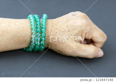 Green prayer beads bracelet worn on the wrists of elderly people. 121647148