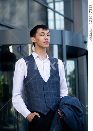Oriental man in suit, business person, manager stands on city center background 121647518