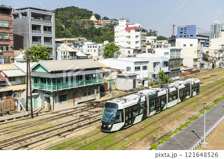 The circular light rail train drives past the former Kaohsiung Port Station North Signal Box, Taiwan. 121648526