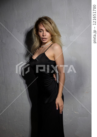 An Elegant Woman in a Beautiful Black Dress Posing Elegantly with Grace and Charm 121651780