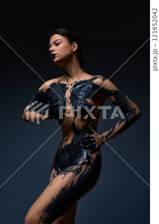 Body painting with naked woman embracing herself against grau backgruond 121652042