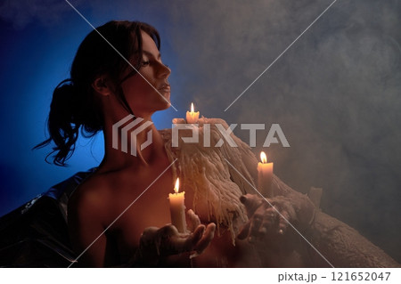 Female model with burning candles in studio 121652047