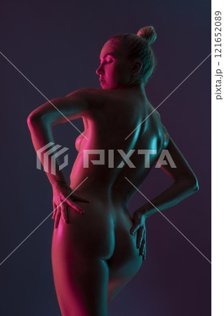 Naked sensual woman standing back with drawn hair on purple background in studio Naked sensual woman standing back with drawn hair on purple background in studio 121652089