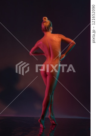 Naked sensual woman standing back with drawn hair on wet surface in studio Naked sensual woman standing back with drawn hair on wet surface in studio 121652090