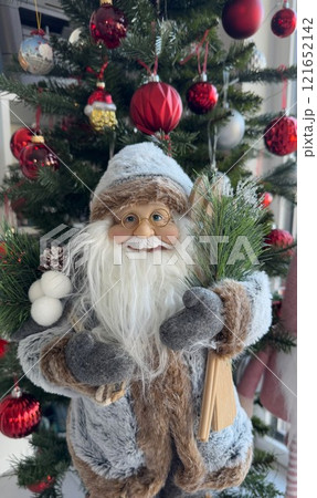 Festive Santa Claus Figurine Against Decorated Christmas Tree Background 121652142