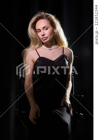 An Elegant Woman in a Beautiful Black Dress Posing Elegantly with Grace and Charm 121652344