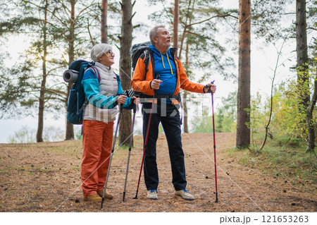 Hiking tourism adventure. Senior couple man woman enjoying outdoor recreation hiking in forest. Happy old people backpackers hikers enjoy walking hike trekking tourism active vacation beauty of nature Hiking tourism adventure. Senior couple man woman enjoying outdoor recreation hiking in forest. Happy old people backpackers hikers enjoy walking hike trekking tourism active vacation beauty of nature 121653263