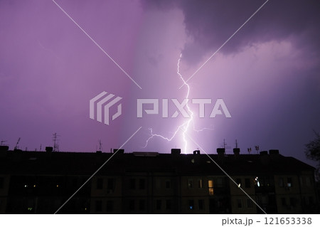Multiple flashes of light and lightning. Lightning electrical spark discharge in atmosphere that occurs during thunderstorm manifested by bright flash of light accompanying thunder. Roof of the house. Multiple flashes of light and lightning. Lightning electrical spark discharge in atmosphere that occurs during thunderstorm manifested by bright flash of light accompanying thunder. Roof of the house. 121653338