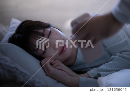 妻が寝ている間にスマホをコッソリ見ようとする夫 妻が寝ている間にスマホをコッソリ見ようとする夫 121656045