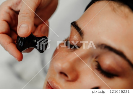 Beauty treatment session focusing on facial massage in a serene spa environment Beauty treatment session focusing on facial massage in a serene spa environment 121656221