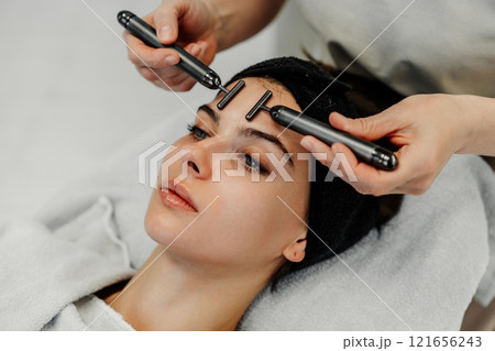 Facial treatment using skincare tools on a young woman in a spa setting Facial treatment using skincare tools on a young woman in a spa setting 121656243
