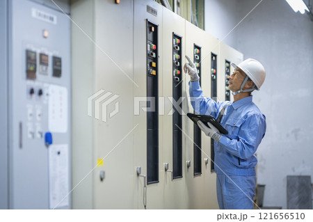 ビルメンテナンススタッフ　イメージ　電気設備の点検をする作業員の横顔 121656510