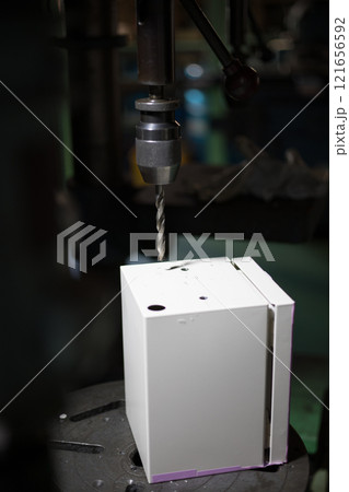 ボール盤で取付穴をあけている作業 121656592