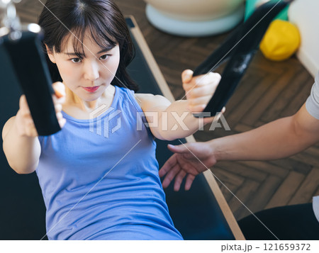 マシンピラティスのレッスンを受ける女性 121659372