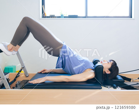 マシンピラティスのトレーニングをする女性 マシンピラティスのトレーニングをする女性 121659380