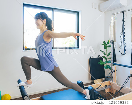 マシンピラティスのトレーニングをする女性 マシンピラティスのトレーニングをする女性 121659382