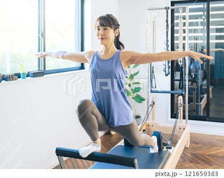 マシンピラティスのトレーニングをする女性 マシンピラティスのトレーニングをする女性 121659383
