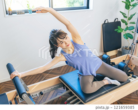 マシンピラティスのトレーニングをする女性 マシンピラティスのトレーニングをする女性 121659385