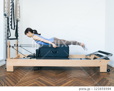 マシンピラティスのトレーニングをする女性 121659394