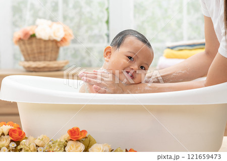 Adorable of asian newborn baby bathing in bathtub.mother bathing her son in warm water.Happy adorable newborn infant smile in tub relax and comfortable.Newborn baby care concept 121659473