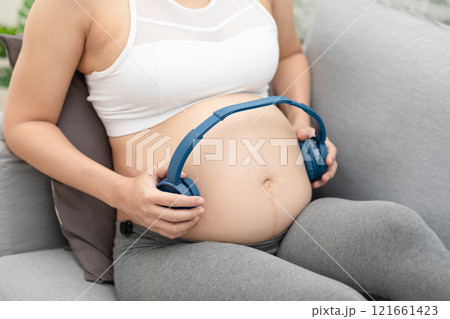 Young Attractive Asian pregnant woman listen music and lying on bed.Pregnant woman use headphones to play classical music for baby in belly learn and Development feeling so relax,Pregnancy Concept Young Attractive Asian pregnant woman listen music and lying on bed.Pregnant woman use headphones to play classical music for baby in belly learn and Development feeling so relax,Pregnancy Concept 121661423