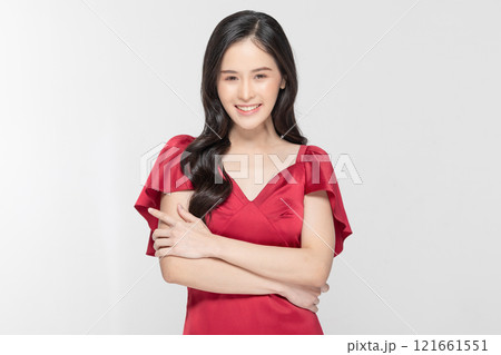 Radiant young woman smiling confidently in a stylish red dress with a white background 121661551