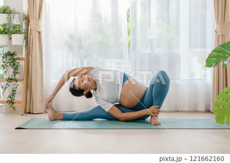 Pregnant woman practicing yoga at home Pregnant woman practicing yoga at home 121662160