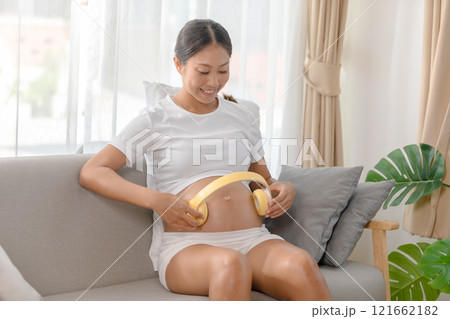 cheerful Asian pregnant woman lounges comfortably cheerful Asian pregnant woman lounges comfortably 121662182