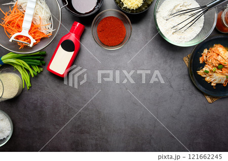 Essential ingredients for making kimchi, fresh vegetables, seasoning and sauces on a dark textured background 121662245